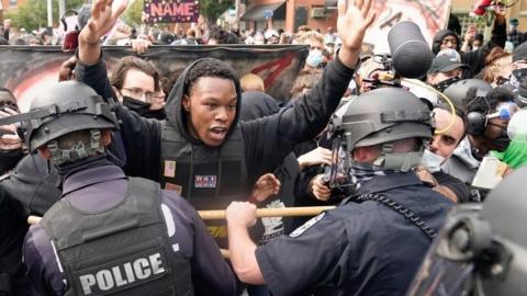 Police and protesters face one another in Louisville following the grand jury's decision (23/09/20)