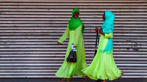 Women laugh as they walk in Georgetown, Guyana, on March 1, 2020