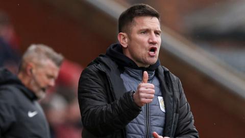 Crewe boss Lee Bell gives the thumbs up to his players from the touchline during a game