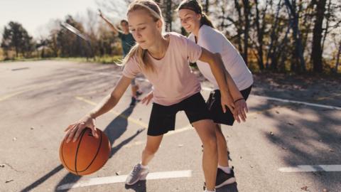 teenagers playing basketball