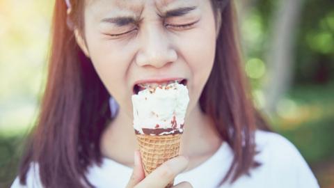 Girl in pain eating ice-cream