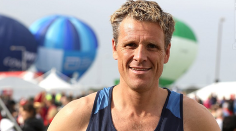 James Cracknell smiling into the camera wearing a rowing vest.