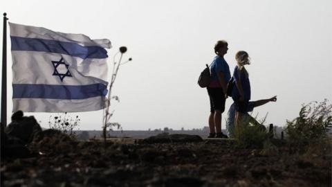 The Tal Saki hill in the Israeli-annexed Golan Heights shows Israelis looking across the border onto Syria during air strikes backing a Syrian-government-led offensive in the southwestern province of Daraa on 24 July 2018