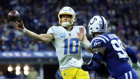 Chargers quarterback Justin Herbert gets the ball away