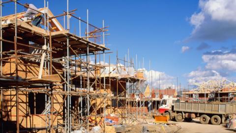 Construction site, workers building four-bedroom houses, England - stock photo