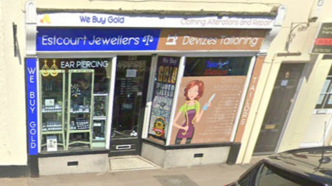 Streetview scene of the shop attacked in Devizes. There is a banner above the shop door which reads "Estcourt Jewellers" in white letters on a blue background