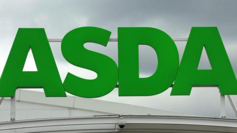 A large green Asda sign on top of one of the supermarket chain's buildings