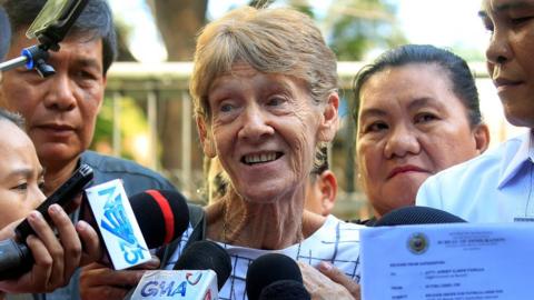 Patricia Fox speaking to reporters outside the immigration bureau in Manila, Philippines