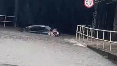 A man helping a woman after flooding