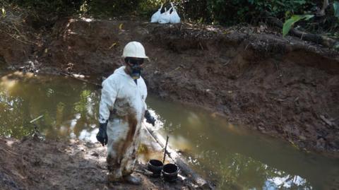 Man cleaning up some of the contaminated soil