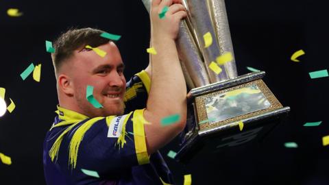 Luke Littler holds the World Darts Championship trophy