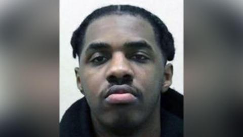 Mugshot of Edwin Taha. He has black hair and is wearing a black hoodie. He is looking directly at the camera and not smiling. 