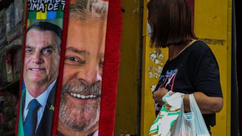 A person walks by a store where towels with images of presidential candidates Lula da Silva and Jair Bolsonaro are sold ahead of Presidential Elections on September 21, 2022 in Sao Paulo, Brazil.