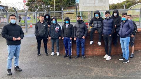 Asylum seekers outside the Penally military training camp