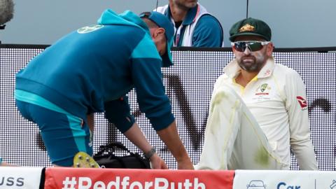 Nathan Lyon sits injured on the boundary at Lord's