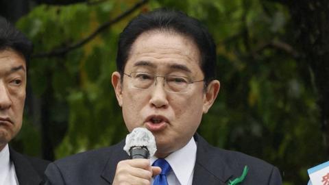 Fumio Kishidia holding a microphone