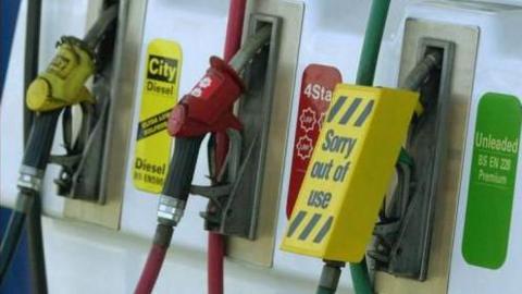 Three pumps at a petrol station, the unleaded pump has a "sorry out of use" label over it. 