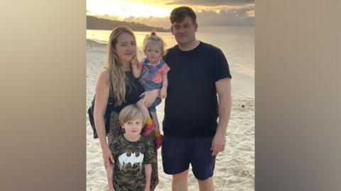 Ceri and Frances Menai-Davis with their two children on a beach