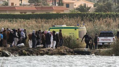 Relatives of the victims of a boat accident gather on the shore of Lake Mariout, near Alexandria, Egypt (23 February 2021)