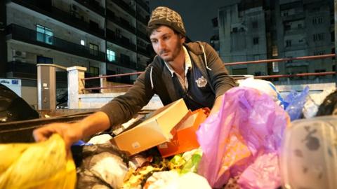Deiri Fayyad, 26, rummages through a large bin in the Lebanese capital Beirut