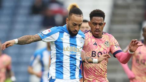 Huddersfield's Sorba Thomas takes on Leeds' Junior Firpo
