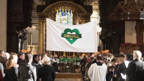 A Grenfell banner being carried into the cathedral