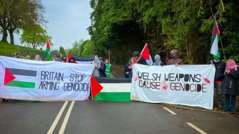 Protestors waving Palestinian flags and holding a banners saying Welsh weapons cause genocide