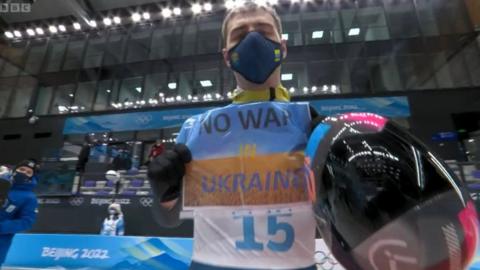 Vladyslav Heraskevych holding up a 'No War In Ukraine' sign