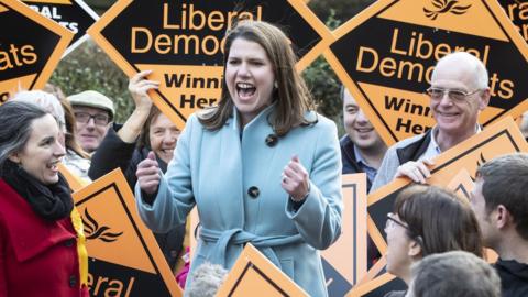 Jo Swinson with Lib Dem activists holding orange placards