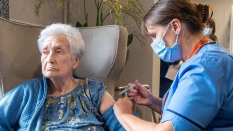 Nurse Laura Hastings administers a covid booster to Agnes Taylor, 93, at Victoria Manor Care home in Edinburgh