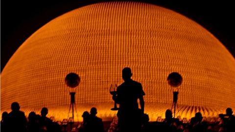 Buddhist monks hold candles in front of the Dhammakaya Temple's illuminated pagoda in Pathumthani province, Thailand on 25 February 2013.