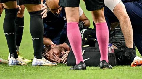 James Maddison lies on the pitch in pain after injuring his knee 