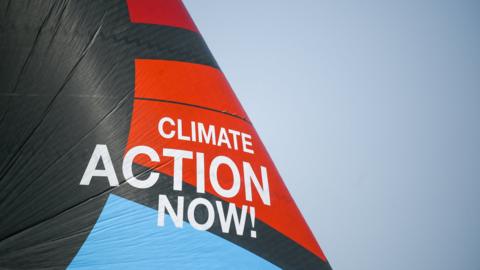 Team Malizia's sail has the 'Climate Action Now!' slogan