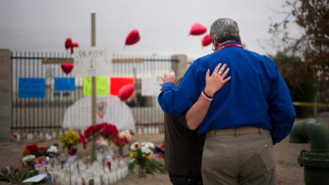 Chaplain Chuck Bender, right, prays with Michael Davila at a makeshift memorial honouring the victims of Wednesday's shooting rampage, Friday, Dec. 4, 2015, in San Bernardino, Calif.