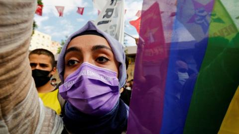 A demonstrator carries a rainbow flag during a protest against an attack on a local office of the pro-Kurdish Peoples' Democratic Party (HDP)