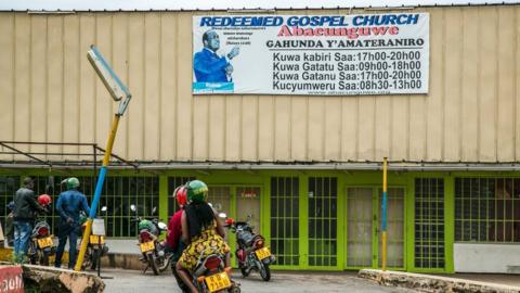 Motorcycle passes the closed entrance to the 'The Redeemed Gospel Church' is in Kigali, Rwanda, on March 1, 2018