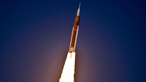 A close up of the rocket taking off, with a dark sky in the background