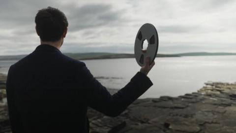 Erland Cooper holds up reel of tape