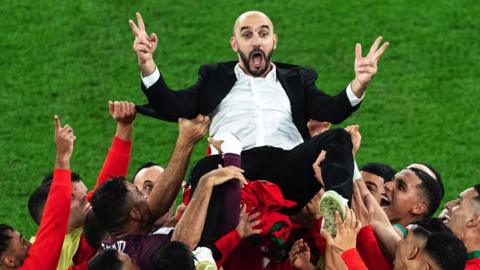 Walid Regragui is thrown in the air after Morocco win a knock-out game at the World Cup