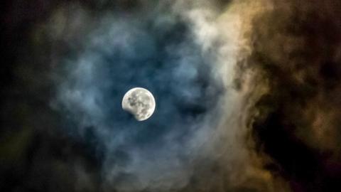 The moon, framed by ashes from the Mount Sinabung volcano, is seen during the peak of the penumbral eclipse from Karo in North Sumatra province on August 8, 2017.