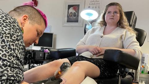 A woman says her scar has been turned into a "beautiful thing" after having a tattoo over it.