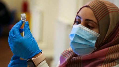 A vaccinator preparing a vaccine in the UK in November