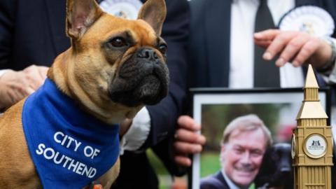 Vivienne, winner of Westminster Dog of the Year, with photo of owner Sir David