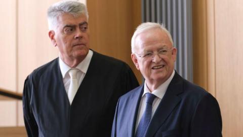 Former Volkswagen head (right) Martin Winterkorn wearing a blue suit, blue spotted tie and glasses during the first day of his trial on September 3, 2024 in Braunschweig, Germany.