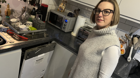 Ellen London-Smith in front of her dishwasher