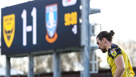 A general view of a player and the scoreboard during an Oxford match