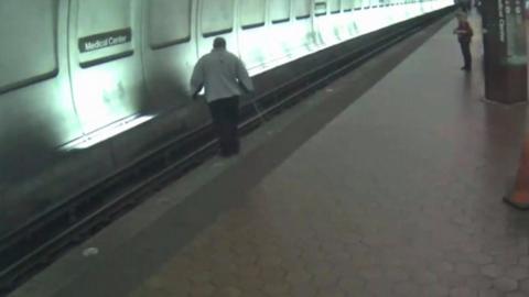 Man on side of subway train tracks