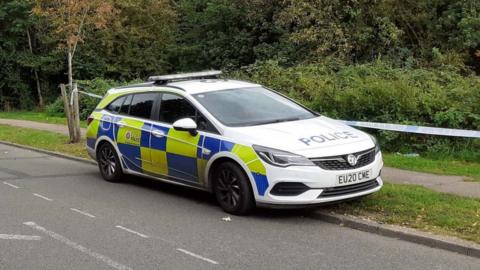 Police car at woodland near to the Oakwood Hill Industrial Estate in Loughton