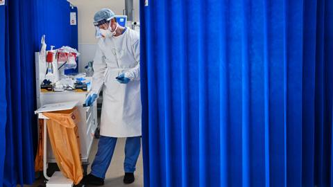 A Nurse at University Hospital Monklands disposes of medical waste on the ICU ward on February 5, 2021 in Airdrie, Scotland.