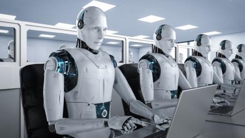 A row of human-like robots at computers